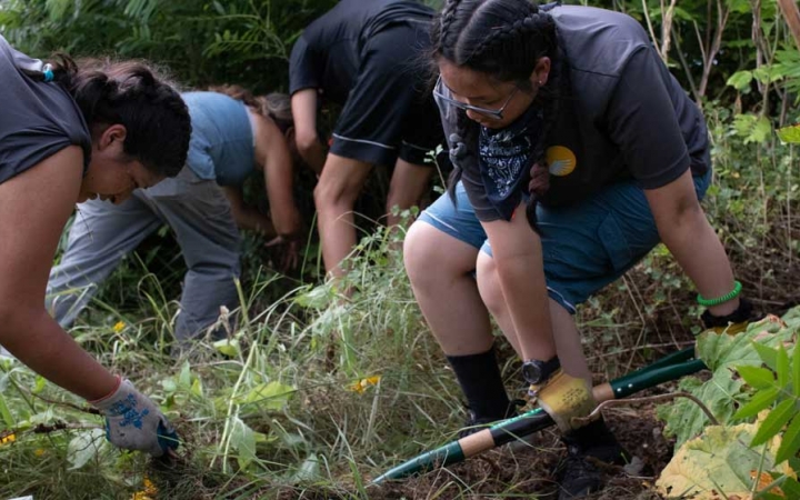 outward bound students use gardening tools during a service project